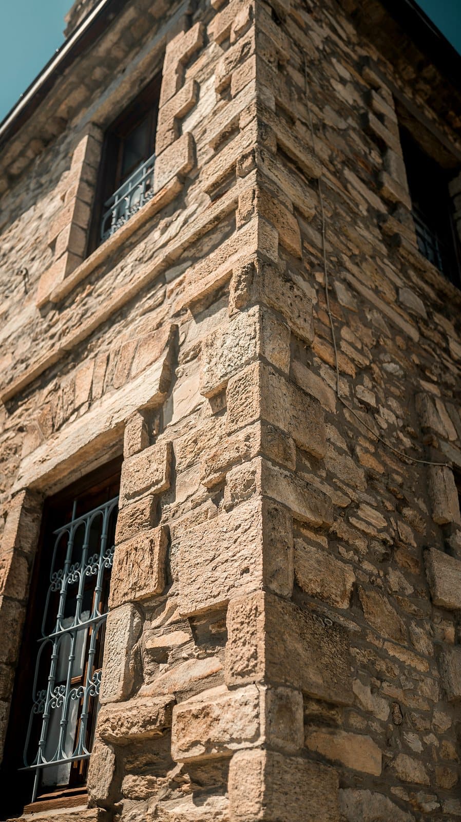 A corner of a stone building showing large dressed cornerstones alternating with rougher fieldstone.